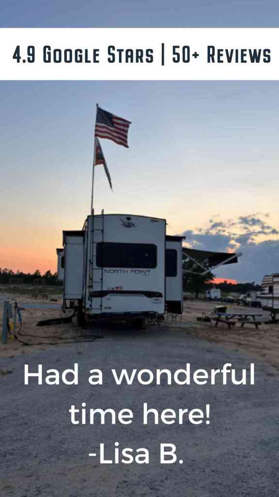 RV with American flag at sunset on spacious campsite at Standing Pines Campground, Hartsville SC